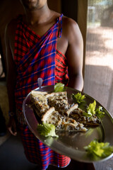 Masai man serving gourmet lunch at safari camp in the masai mara, kenya