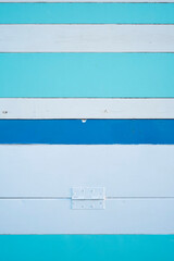 Bisagra en pared de tablones blancos y azules en caseta de playa