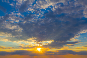 Naklejka na ściany i meble evening sun on blue cloudy sky at the evening, dramatic sunset background