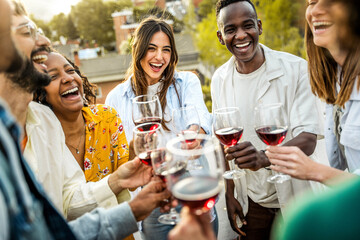Happy friends toasting red wine glasses outside - Group of young people having bbq dinner party in backyard house - obrazy, fototapety, plakaty