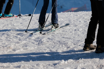 concetto di: sciare in montagna, primo piano sulle gambe di varie persone irriconoscibili che si preparano per sciare su una pista da sci, in inverno, in montagna