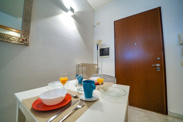 Stylish and sunny kitchen interior with accessories and table. Design space of a Bed and Breakfast