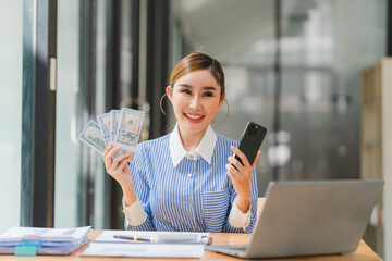 Asian Young woman holding 100 dollars bank notes screaming proud and celebrating victory and success very excited, cheering emotion