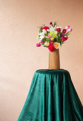 beautiful flowers  in vase on table on background wall