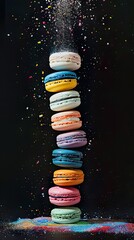 A stack of colorful macarons with chocolate powder falling on top, black background - 795066971