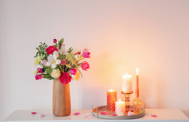  flowers  in vase and burning candles on shelf  on background wall - 795067318