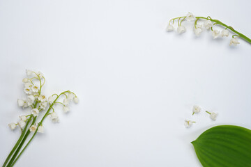 Flat lay frame from spring flowers Lily of the valley (Convallaria majalis) on a white background. Beautiful floral frame. Springtime. Top view, flat lay. Space for text. 