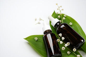 Glass bottles and a flower of a lily of the valley on a white background. Knolling style...