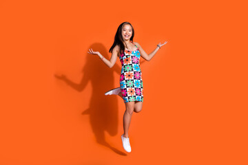 Full size photo of lovely woman wear flower print dress flying palms demoonstarte objects empty space isolated on orange color background