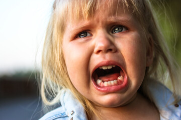 Unhappy child crying loudly with mouth open because of parents' divorce. Negative emotions....
