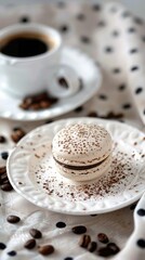 A delicate macaron with a coffee powder dusting, placed on an elegant white plate and set against the backdrop tablecloth with a steaming cup of black or latte espresso, - 795080913