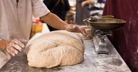 Male hands knead yeast dough for baking bread