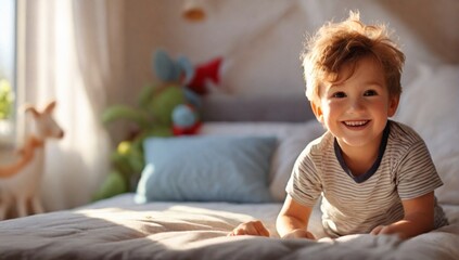 Naklejka premium Cute little happy child boy playing in parents bed having fun at home at sunny morning. Light and shadows 