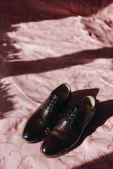 brown leather shoes on a dark pink background