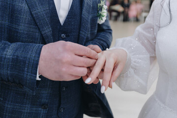 Obraz na płótnie Canvas caucasian bride and groom exchange wedding rings