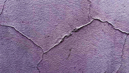 Grunge violet shabby wall with cracked paint. Background with copy space. Abstract wallpaper for background. Film grain texture. Soft focus. Blur