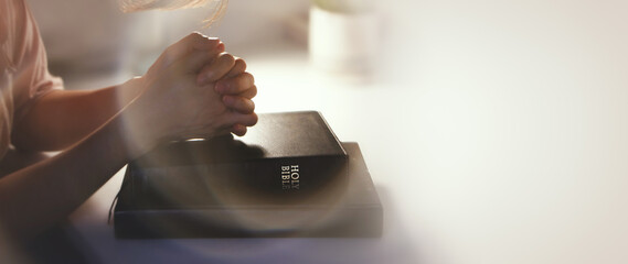 Christian background with hands placed together on a holy bible at a desk, meditating, praying and...