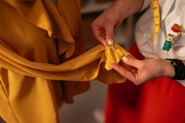 Close-up of hands pinning fabric on garment
