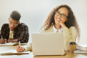Student, laptop and portrait in classroom writing notes for college, course test and campus work....