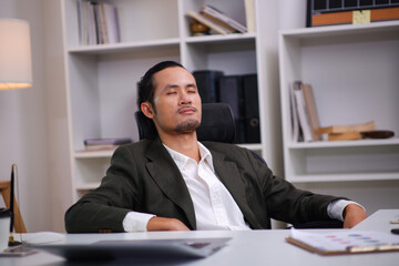 Obraz premium Businessman sits, relaxes and closes his eyes