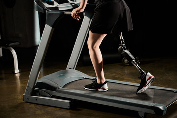 A determined man with a prosthetic leg is running on a treadmill in a gym.