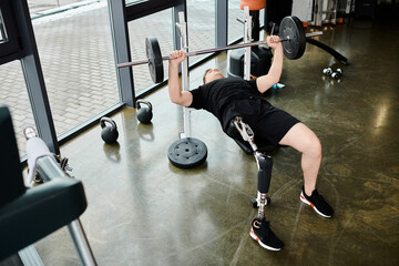 A man with a prosthetic leg performs a powerful deadlift in a gym, showcasing determination and...
