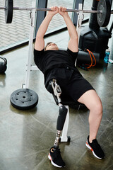 A disabled man with a prosthetic leg wearing a black shirt performs a barbell squat in a gym.