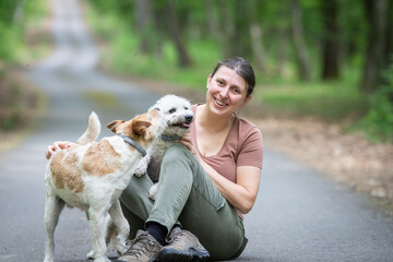 happy woman with her dogs in the forest