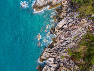 Aerial top down view of a beach with turquoise clear water rocks and trees in Koh Phangan Thailand