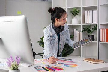 Female designer working in graphic design Choose colors for working on tablets and computer designs.