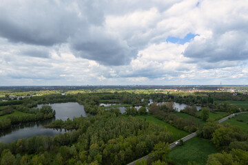 An aerial view of a lush green forest with a lake under a clear blue sky Hanover Germany