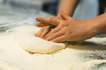 hands steading the dough in the flour, working in the kitchen. High quality photo