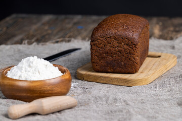 a square dark loaf of bread on the table