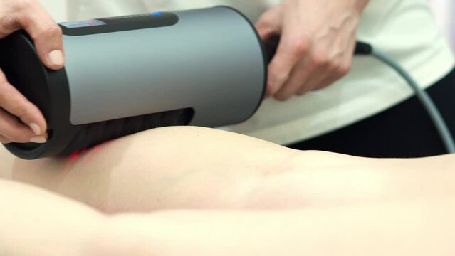 RGL apparatus sculpting. Figure correction using hardware massage for weight loss. Anti-cellulite and drainage massage. Beauty and body care. A woman lies on a massage table.