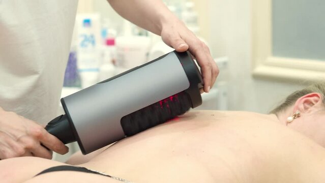 RGL apparatus sculpting. Figure correction using hardware massage for weight loss. Anti-cellulite and drainage massage. Beauty and body care. A woman lies on a massage table.