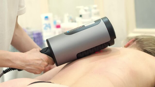 RGL apparatus sculpting. Figure correction using hardware massage for weight loss. Anti-cellulite and drainage massage. Beauty and body care. A woman lies on a massage table.