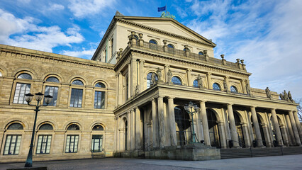 Tall building with columns under a blue sky, showcasing a beautiful facade Hanover Germany