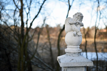 Ukraine, Kyiv 19.01.2024. angel statue in the park. little boy with wings. cupid statue in autumn...