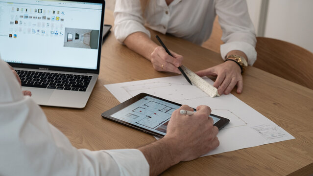 Interior architect working in the office with plans and materials.