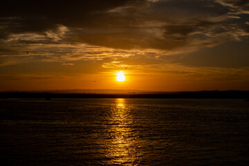 sunset and beachPrecious delayer on the beach a late summer. Sky with falling clouds as the sun reflects on the waves of the sea as it disappears.