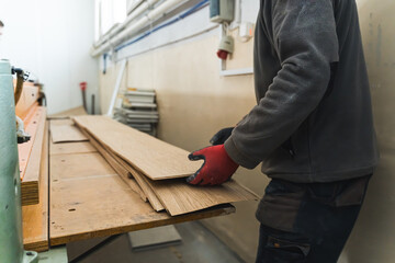 Carpenter moving large scale wooden planks at the workshop. High quality photo