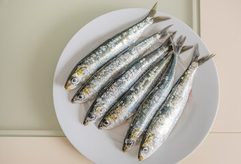 Half a dozen appetizing raw and fresh sardines from the Atlantic Ocean, on a plate. Purchased at...