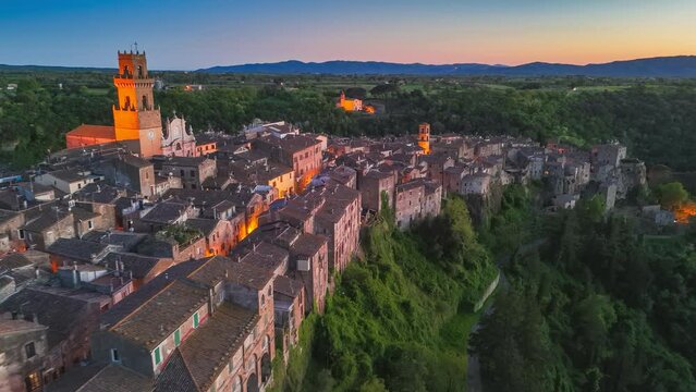 Pitigliano old town with city light after sunset. Aerial evening shot of Pitigliano, Tuscany, Italy