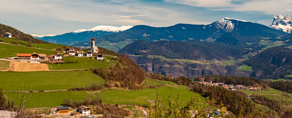 Alpine spring view with a distant church seen from near Klobenstein, Ritten, Eisacktal valley, South Tyrol, Italy