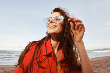 Fototapeta premium Smiling Woman at the Beach, Embracing Freedom and Nature