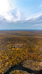 Obraz premium Aerial autumn river curve in colorful forest on hills vertical panorama