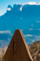 Alpine spring view with details of a wooden fence and Mount Schlern, dolomites, in the background...