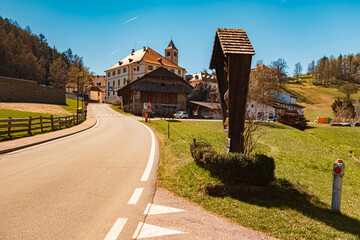 Alpine spring view with a religious cross near Klobenstein, Ritten, Eisacktal valley, South Tyrol,...