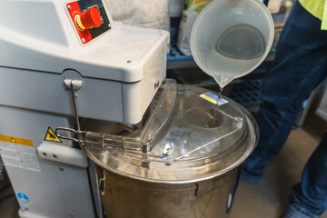 adding water in an electric mixer machine in the kitchen. High quality photo