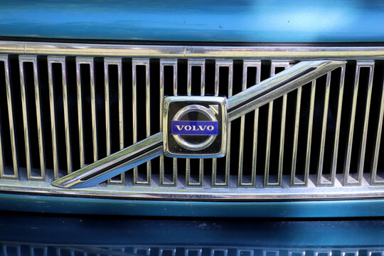 Detail of grill and classic blue Volvo car. Volvo logo. Outdoor exhibition of old classic cars.